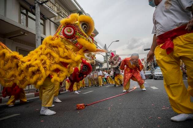 September 25, 2022, Bangkok, Bangkok, Thailand: Traditional Chinese lion dancers jump as fireworks explode in the street on the first day of the Vegetarian Festival. The annual Vegetarian Festival, which derives from Chinese religious influences, began today in cities throughout Thailand. Bangkokâ€⠢s historic Yaowarat Chinatown saw the start of the 11 day long event, with food stalls lining the streets selling vegan food. Bangkok Thailand - ZUMAt128 20220925_zap_t128_008 Copyright: xAdryelxTalamantesx