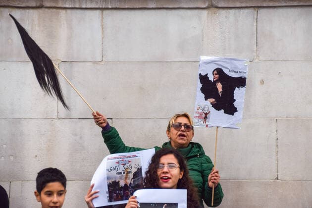September 27, 2022, London, United Kingdom: A protester holds a picture of Mahsa Amini and a stick with chopped hair during the demonstration in Trafalgar Square. Protesters continue to gather in London in response to the death of Mahsa Amini, who died in police custody in Iran after being detained for allegedly not wearing a head scarf (hijab) properly in public. London United Kingdom - ZUMAs197 20220927_zaa_s197_109 Copyright: xVukxValcicx