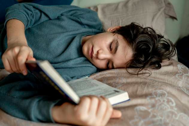 Boy reading novel lying on bed at home model released, Symbolfoto property released, ANAF00494