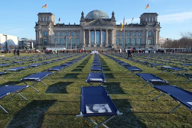19 01 2023, Berlin, DEU At a demonstration by LongCovid and ME CFS sufferers on the lawn in front of the Reichstag building, 400 cots with portraits of sufferers from all over Germany were set up