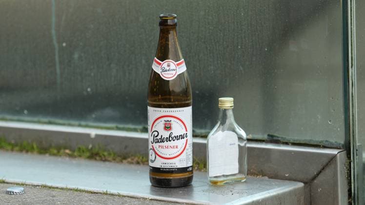 An empty beer bottle of the brand Paderborner as well as empty liquor bottle stand on a staircase in the Hamburg old town symbol picture alcohol addiction old town Hamburg