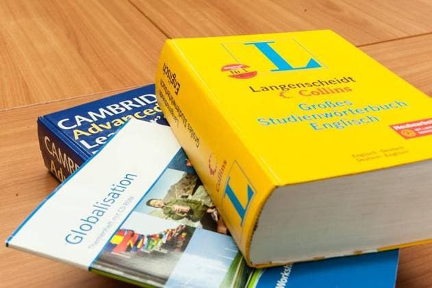 <p>Bilingualer Unterricht am Berufskolleg in Hattingen, Schulträger ist der Ennepe Ruhr Kreis, hier im Bild Lehrer Withold Lohmann (59) unterrichtet in seinen Fächern Informatik, Englisch, Soziologie und General Studies (Allgemeinbildung) sowohl in Englisch als auch in Deutsch, hier für ein Foto im Konferenszraum mit Unterrichtsmaterial im PC, Wörterbücher Deutschland NRW Hattingen Copyright: VolkerxSpeckenwirth
