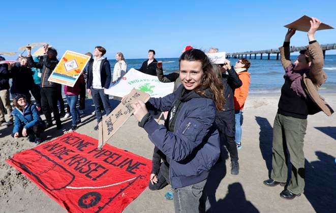 Climate activists demonstrate on Ruegen Climate activist Luisa Neubauer M demonstrates at the seaside bridge in Binz County Western Pomerania Ruegen against a possible LNG terminal on the island of Ruegen Almost 100 activists and sympathizers participate in event on the Baltic Sea beach Neubauer said she had come at the invitation of Ruege