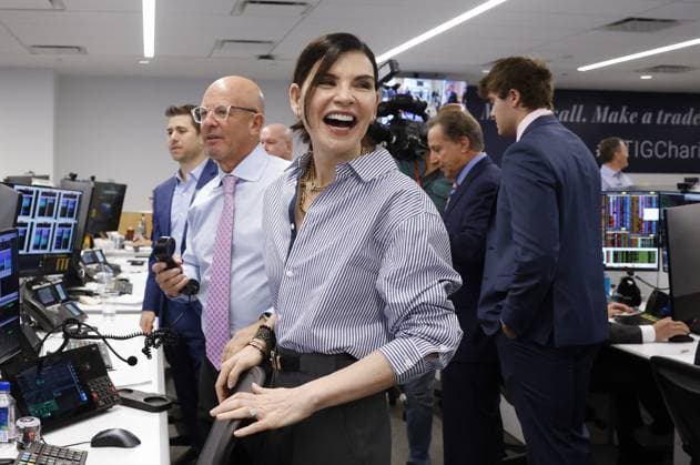 BTIG Co-Founder Steven Starker and actress Julianna Margulies speak to a client at the 2023 BTIG Commissions for Charity Day in New York City on May 2, 2023.  NYP20230502110 JOHNxANGELILLO