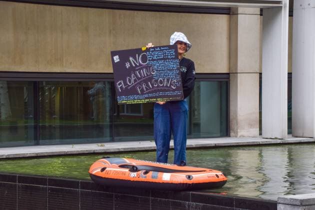 May 22, 2023, London, England, United Kingdom: An activist from the pro-refugee organisation Reclaim The Sea stands with an inflatable boat in the water feature outside the Home Office in protest against the Bibby Stockholm migrant barge. London United Kingdom - ZUMAv130 20230522_zip_v130_004 Copyright: xVukxValcicx