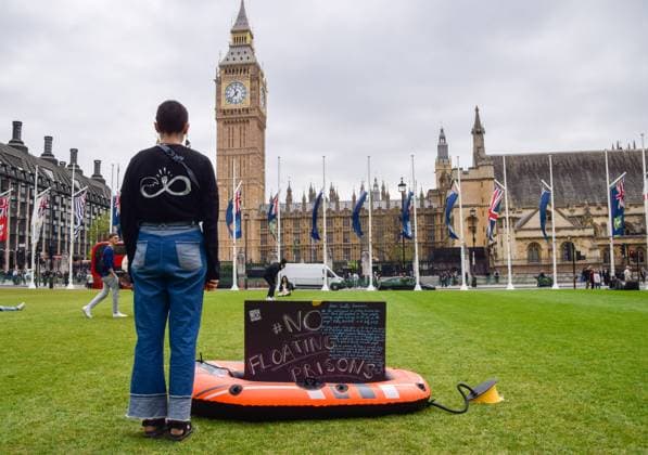May 22, 2023, London, England, United Kingdom: An activist from the pro-refugee organisation Reclaim The Sea stands with an inflatable boat in Parliament Square in protest against the Bibby Stockholm migrant barge. London United Kingdom - ZUMAv130 20230522_zip_v130_010 Copyright: xVukxValcicx