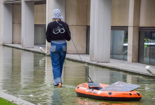 May 22, 2023, London, England, United Kingdom: An activist from the pro-refugee organisation Reclaim The Sea pulls an inflatable boat in the water feature outside the Home Office in protest against the Bibby Stockholm migrant barge. London United Kingdom - ZUMAv130 20230522_zip_v130_018 Copyright: xVukxValcicx
