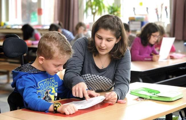 <p>Als Vorreiterschule im Bereich Inklusion gilt in Gelsenkirchen die Grundschule an der Erzbahntrasse im Ortsteil Hüllen. 29 der insgesamt 248 Schüler besitzen einen besonderen Förderbedarf. Am Dienstag, dem 04.02.2014, unterstützt Anna Quattroventi, die ein freiwilliges soziales Jahr an der Schule absolviert (FSJ) den achtjährigen Lukas im Unterricht der Klasse 3. Deutschland NRW Gelsenkirchen Copyright: MartinxMöller