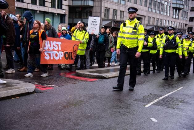 November 18, 2023, London, United Kingdom: A group of protestors hold a banner marching alongside policemen during the demonstration. JUST STOP OIL organisers come together to demand an end to new oil and gas. They state that, The government is waging war on its people, and are fighting back. They re imprisoning peaceful protestors, protecting the real criminals, and licensing more than 100 new oil and gas projects. London United Kingdom - ZUMAs197 20231118_aaa_s197_043 Copyright: xLoredanaxSangiulianox