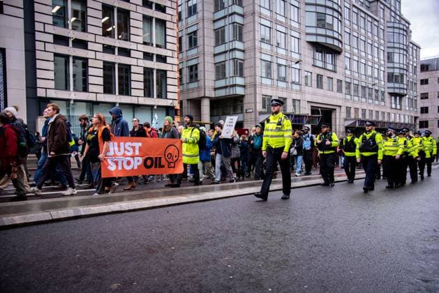 November 18, 2023, London, United Kingdom: A group of protestors hold a banner marching alongside policemen during the demonstration. JUST STOP OIL organisers come together to demand an end to new oil and gas. They state that, The government is waging war on its people, and are fighting back. They re imprisoning peaceful protestors, protecting the real criminals, and licensing more than 100 new oil and gas projects. London United Kingdom - ZUMAs197 20231118_aaa_s197_047 Copyright: xLoredanaxSangiulianox