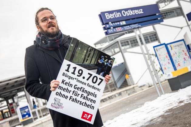 Organizer Arne Semsrott with a poster in front of the protest reading against the criminalization of driving without a ticket at Ostkreuz in Berlin on 5 December 2023 Protest reading against the criminalization of driving without a ticket