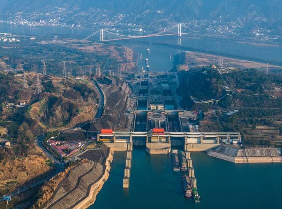 (240111) -- YICHANG, Jan. 11, 2024 -- An aerial drone photo taken on Jan. 11, 2024 shows vessels passing through the five-tier ship locks of the Three Gorges Dam in Yichang, central China s Hubei Province. The cargo throughput via the Three Gorges Dam, the world s largest hydropower project on the upper stream of the Yangtze River, reached a record high of 172.34 million tonnes in 2023, up 7.95 percent year on year, according to the China Three Gorges Corporation. (Photo by Xinhua) CHINA-HUBEI-YICHANG-THREE GORGES DAM-CARGO THROUGHPUT (CN) WangxGang