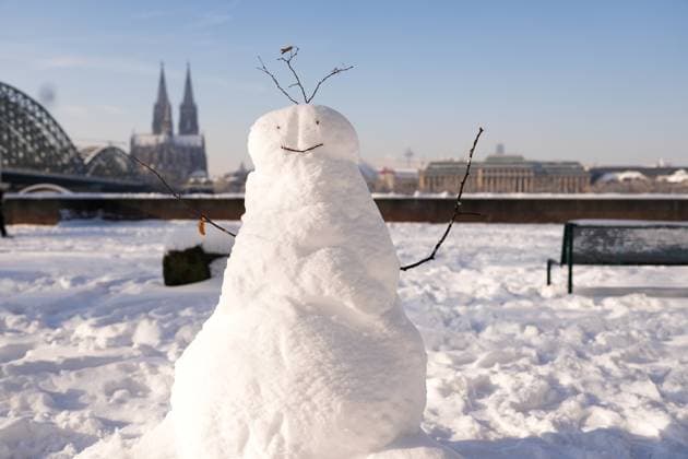 Impressions of the onset of winter and snow in Cologne Impressions and impressions of the onset of winter with snow and snow masses in the cathedral city with a snowman against the background of Cologne Cathedral The city under a magical blanket of snow, a winter fairy tale Cologne, 18 01 2024 Cologne North Rhine-Westphalia Germany