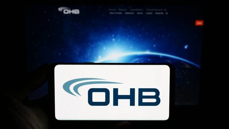 Person holding smartphone with logo of German aerospace company OHB SE on screen in front of website Stuttgart, Germany - 09-10-2023: Person holding smartphone with logo of German aerospace company OHB SE on screen in front of website. Focus on phone display. Copyright: xZoonar.com TimonxSchneiderx 21082533