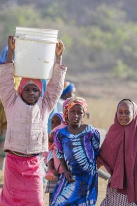 Girl carrying a heavy water bucket on her head, Maraban Dare, 07 02 2024 Maraban Dare Nigeria Copyright: xUtexGrabowskyxphotothek.dex