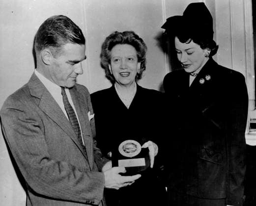Don Wilson, district traffic and sales manager of United Airlines presents a plaque to Elizabeth Arden making her a member in the 100,000 air miles club. Miss Bea Ranson, right is director of the Women s division of United Airlines. January 16, 1950.  Copyright: xCopyrightxUnknownx 5513-48217643