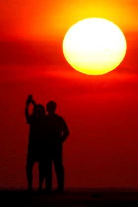 May 8, 2024, Isle Of Palms, Sc, United States: A couple, silhouetted by the sunrise, takes a selfie as the beach season along the Low Country region began in earnest with sunny skies and temperatures in the mid-80Ã¢â‚¬â ¢s, May 8, 2024 in Isle of Palms, South Carolina. Isle Of Palms United States - ZUMAe02_ 20240508_zaf_e02_001 Copyright: xRichardxEllisx