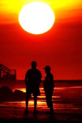 May 23, 2024, Isle Of Palms, Sc, United States: A couple silhouetted by the sunrise, watch as the fireball of a sun, rises over the Atlantic Ocean horizon, May 23, 2024 in Isle of Palms, South Carolina. Isle Of Palms United States - ZUMAe02_ 20240523_zaf_e02_005 Copyright: xRichardxEllisx