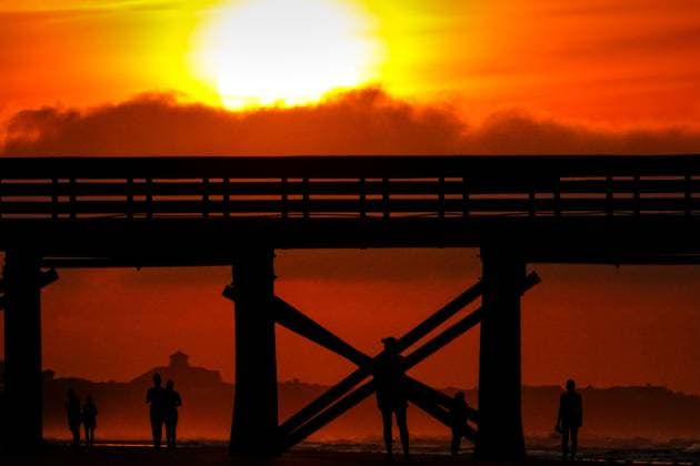 May 24, 2024, Isle Of Palms, Sc, United States: Beachgoers are silhouetted by the sunrise under the Isle of Palm Pier, May 24, 2024 in Isle of Palms, South Carolina. Crowds of vacationers have begun arriving for the three-day Memorial Day weekend, the unofficial start of the beach season. Isle Of Palms United States - ZUMAe02_ 20240524_zaf_e02_002 Copyright: xRichardxEllisx
