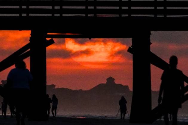 May 24, 2024, Isle Of Palms, Sc, United States: Beachgoers are silhouetted by the sunrise under the Isle of Palm Pier, May 24, 2024 in Isle of Palms, South Carolina. Crowds of vacationers have begun arriving for the three-day Memorial Day weekend, the unofficial start of the beach season. Isle Of Palms United States - ZUMAe02_ 20240524_zaf_e02_003 Copyright: xRichardxEllisx