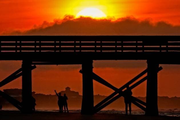 May 24, 2024, Isle Of Palms, Sc, United States: Beachgoers are silhouetted by the sunrise under the Isle of Palm Pier, May 24, 2024 in Isle of Palms, South Carolina. Crowds of vacationers have begun arriving for the three-day Memorial Day weekend, the unofficial start of the beach season. Isle Of Palms United States - ZUMAe02_ 20240524_zaf_e02_005 Copyright: xRichardxEllisx