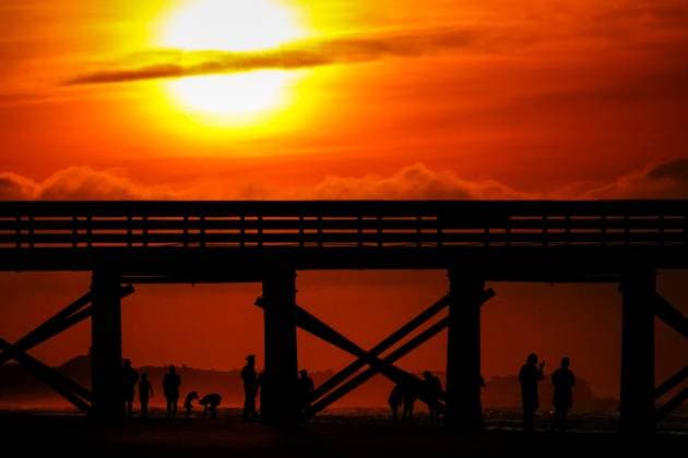 May 24, 2024, Isle Of Palms, Sc, United States: Beachgoers are silhouetted by the sunrise under the Isle of Palm Pier, May 24, 2024 in Isle of Palms, South Carolina. Crowds of vacationers have begun arriving for the three-day Memorial Day weekend, the unofficial start of the beach season. Isle Of Palms United States - ZUMAe02_ 20240524_zaf_e02_004 Copyright: xRichardxEllisx