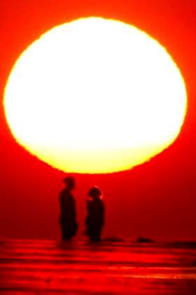 May 29, 2024, Isle Of Palms, Sc, United States: A couple, silhouetted by the sunrise, takes a selfie on the beach as a heat wave sweeps across the region bringing temperatures into the 90Ã¢â‚¬â ¢s, May 29, 2024 in Isle of Palms, South Carolina. Isle Of Palms United States - ZUMAe02_ 20240529_zaf_e02_007 Copyright: xRichardxEllisx