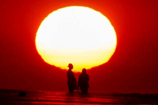 May 29, 2024, Isle Of Palms, Sc, United States: A couple, silhouetted by the sunrise, takes a selfie on the beach as a heat wave sweeps across the region bringing temperatures into the 90Ã¢â‚¬â ¢s, May 29, 2024 in Isle of Palms, South Carolina. Isle Of Palms United States - ZUMAe02_ 20240529_zaf_e02_001 Copyright: xRichardxEllisx