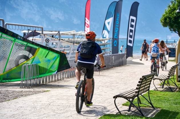 Torbole, Lake Garda, Italy - June 27, 2024: Cyclists ride their bikes around Lake Garda and take a bike tour along the circular path along the lake in Italy.