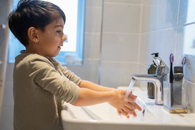 Boy (6-7) washing hands in bathroom model released Copyright: xCulturaxCreativex