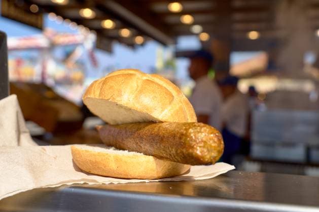 Munich, Bavaria, Germany - September 23, 2024: Vegan bratwurst in a bun at the Oktoberfest can be seen at one of the numerous food stalls. The vegan sausage is traditionally served in a roll and offers a plant-based alternative to the otherwise meat-heavy specialties of the festival