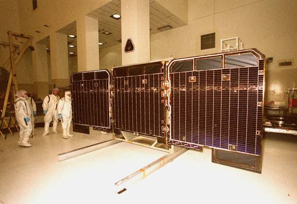 RECORD DATE NOT STATED Workers in the Spacecraft Assembly and Encapsulation Facility -2 make a visual check of the front side of the opened solar array panels from the 2001 Mars Odyssey Orbiter. The Mars Odyssey carries three science instruments the Thermal Emission Imaging System (THEMIS), the Gamma Ray Spectrometer (GRS), and the Mars Radiation Environment Experiment (MARIE). THEMIS will map the mineralogy and morphology of the Martian surface using a high-resolution camera and a thermal infrared imaging spectrometer. The GRS will achieve global mapping of the elemental composition of the surface and determine the abundance of hydrogen in the shallow subsurface. The GRS is a rebuild of the instrument lost with the Mars Observer mission. The MARIE will charact Copyright: xpiemagsx piemagsnasaend23-15681 !ACHTUNG AUFNAHMEDATUM GESCHÄTZT!