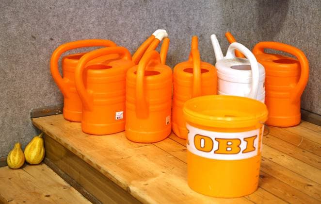 Rassekaninchen Ausstellung 08 12 2024, Frohndorf, Rassekaninchen Ausstellung in the picture at the edge of the exhibition are watering cans in orange and white, in front of it a bucket with the inscription OBI