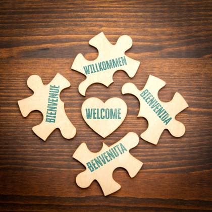 WELCOME. English Italian German Spanish French. Wooden puzzle in the shape of a heart on a wooden texture background. Copyright: xEdgarsxSermulisx