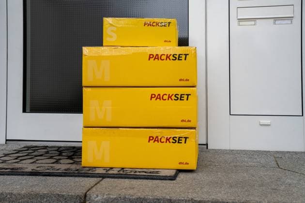 Bavaria, Germany - December 9, 2024: Symbolic image: DHL parcels in front of a front door - an example of international shipping. Customers should find out about the relevant customs regulations, delivery times and possible additional costs before shipping abroad. Clear addressing and complete documentation help to avoid delays or returns.