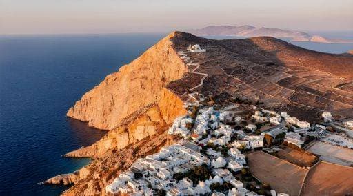 Aerial view of a coastal village with white buildings and a mountain in Folegandros, Greece during sunset 25268872 RECORD DATE NOT STATED