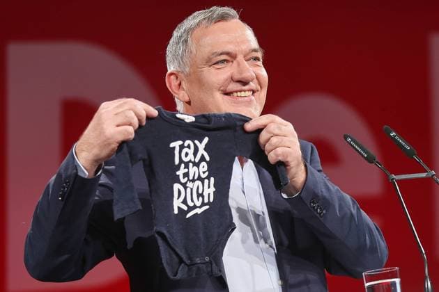 Berlin, Germany, 18 01 2025 Event hall Station Extraordinary party conference of the Left Party for the 2025 Bundestag elections Top candidate and party leader Jan van Aken holds up a baby bodysuit with the inscription Tax the Rich , because he has become a grandpa Copyright: xdtsxNachrichtenagenturx dts_56153