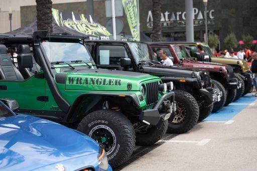 RECORD DATE NOT STATED Several highly modified Jeep Wrangler brand off-road vehicles parked in battery at a car meeting. The first is a green second generation Wrangler TJ 25716175