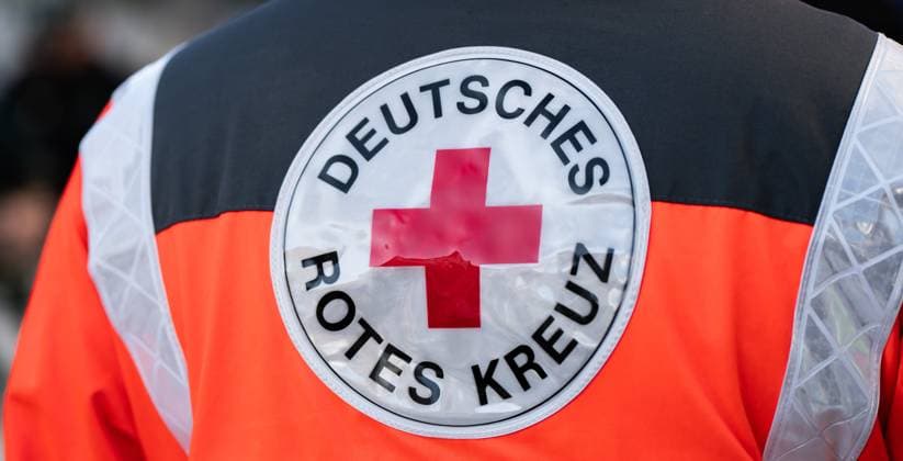 A paramedic wears a jacket with the logo and the lettering German Red Cross Vöhringen Baden Württemberg Germany