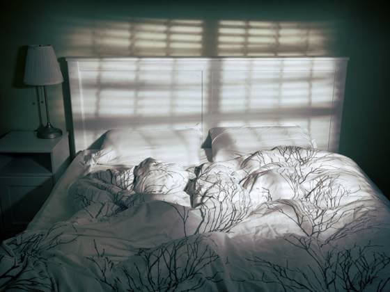 Ungemachtes leeres Bett in dramatischem gedämpftem Licht, das von einem Fenster durch Jalousien kommt Unmade empty bed in dramatic dim light coming from a window through blinds Copyright: imageBROKER OleksiyxMaksymenko ibxalx12091065.jpg