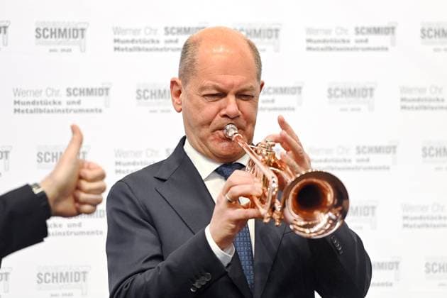 Tour of the trade fair Federal Chancellor Olaf SCHOLZ, at a stand of a company for metal wind instruments, playing a jazz trumpet Top-level talk of the German economy on 14 03 2025 at the International Craft Fair IHM Munich
