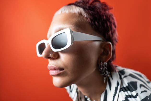 Creative Highlights Symbolfotos Close-up of a fashion model wearing white sunglasses and zebra animal print attire, set against a vibrant orange backdrop. The studio flash photography creates a striking and modern look. Model Released ManuelRuiz_ID27375_785302_009 Copyright: xManuelxRuizx
