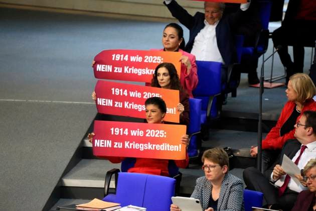 Berlin, 18 03 2025 213 Session of the German Bundestag Members of the BSW group hold posters with the inscription 1914 like 2025 No to war loans Second and third deliberation of the draft bill introduced by the SPD and CDU CSU parliamentary groups to amend the Basic Law Articles 109, 115, 143h Berlin Germany Copyright: xMatthiasxGränzdörferx
