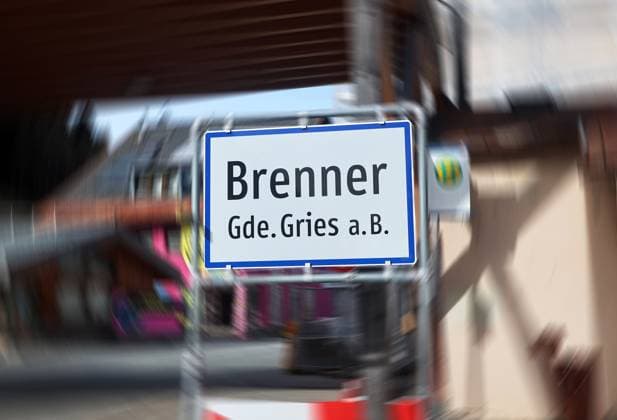 ATTENTION IMAGE EDITED Here is the view of the town sign, town sign with the lettering Brenner, municipality of Gries am Brenner, heavily frequented, traffic jam, impairment in vacation traffic, trucks, day trippers, tourist traffic, transit route, north-south connection, vacation traffic, the background has been dynamically blurred