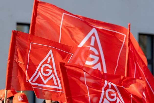 IG Metall warning strikes in the Bavarian automotive trade, Nuremberg, 02 04 2025 Several red flags with the IG Metall logo can be seen during a union rally In the background people wear red caps with the emblem of the union The focus is on the waving flags in the foreground Nuremberg Bavaria Germany 20250402-6V2A6599-M4000