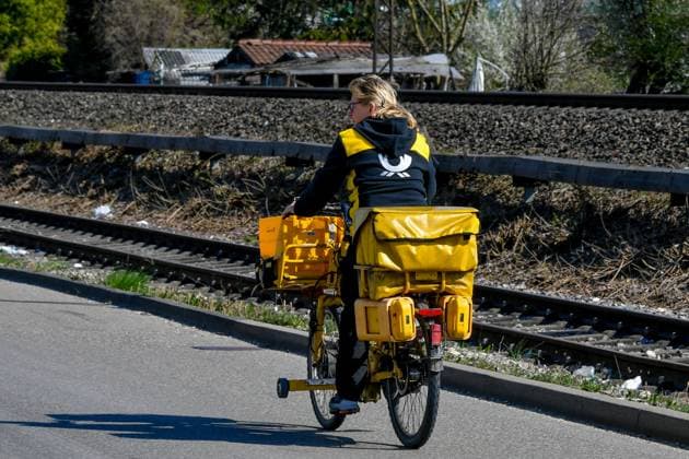 Germany, Baden Wuerttemberg, Ebersbach an der Fils 05 04 2025, Germany, GER, Baden Wuerttemberg, Ebersbach an der Fils, in the picture theme picture, Deutsche Post, postwoman, mail carrier, bicycle, delivery, mail, letters, parcels, packages, DHL Baden Wuerttemberg Deutschland, Baden-Wuerttemberg, Ebersbach an der Fils, 05.04.2025-2