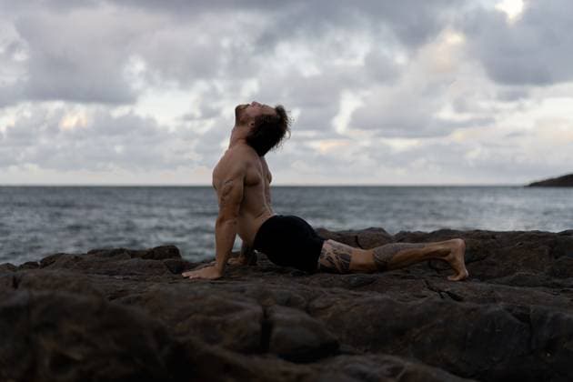 Man practices yoga at a rocky beach by the ocean Sunshine Coast, Queensland, Australia CR_YUKI250421-1709042-01 ,model released, Symbolfoto