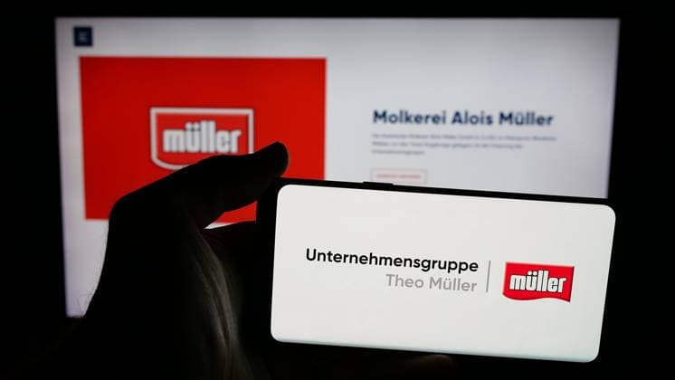 Photo illustration in Germany - 24 Apr 2025 In this photo illustration, a person is holding a mobile phone with the logo of dairy company Unternehmensgruppe Theo Muller on screen in front of webpage. Germany Copyright: xTimonxSchneiderx xSOPAxImagesx TSCHNEIDER_50516 Unternehmensgruppe Theo Mueller P4170702