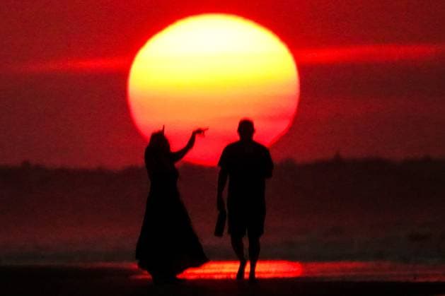 May 20, 2025, Isle Of Palms, Sc, United States: A couple, silhouetted by the sunrise walks toward the sun as it climbs over the horizon at Front Beach, May 20, 2025 in Isle of Palms, South Carolina. Isle Of Palms United States - ZUMAe02_ 20250520_zaf_e02_001 Copyright: xRichardxEllisx