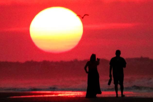 May 20, 2025, Isle Of Palms, Sc, United States: A couple, silhouetted by the sunrise watches as the sun climbs over the horizon at Front Beach, May 20, 2025 in Isle of Palms, South Carolina. Isle Of Palms United States - ZUMAe02_ 20250520_zaf_e02_006 Copyright: xRichardxEllisx